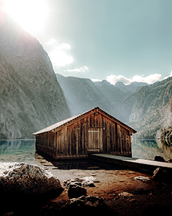 picture of a cabin near a sunny lake